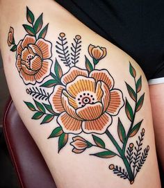 a woman's thigh with an orange flower and leaves tattoo design on her leg