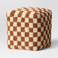 a brown and white checkerboard pattern poufce on a gray background in the shape of a cube