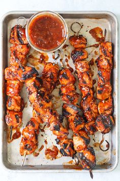 chicken skewers on a tray with sauce