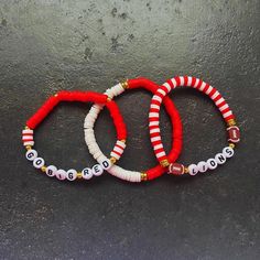 Set of 3 Lansing Lions Game Day hand-beaded, stretch bracelets. Each strand is made with 6 mm clay beads with gold accents. Free shipping on orders $35 and over is guaranteed. Details:  🖤Handmade Item 🖤Ships from Lansing, KS  🖤Bracelet Length: 7" (Standard) 🖤Materials: Heishi Clay Disc Beads, Gold color Beads, Letter Beads 🖤Closure: Tie 🖤Made to Order ✨ Please measure your wrist before ordering as we do not offer returns or exchanges for resizing.  ✨You may request custom sizes in the pers Red Hand-strung Friendship Stretch Bracelet, Red Heishi Beads Bracelet For Gift, Red Heishi Beads Jewelry With Letter Beads, Red Heishi Bead Jewelry With Letter Beads, Red Adjustable Heishi Beads Stretch Bracelet, Handmade Red Stretch Bracelet With Heishi Beads, Lion Games, Bracelets Stack, Lion Bracelet