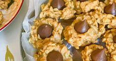 chocolate covered cookies are on a plate next to a bowl