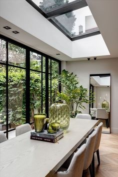 a dining room table with two vases on top of it and some chairs around it