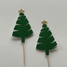 two green christmas trees with gold stars on them, one is shaped like a tree and the other is made out of wood sticks