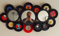 a man taking a selfie in front of a mirror with many records on it