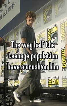 a man standing on top of a stage in front of a sign with the words, the way half the teenage population have a crushon him