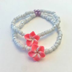 this bracelet is made of strong, stretchy string! the pink plumeria beads adds just enough color to the bracelet and gives it a beachy accent! the bracelet will come in a small drawstring mesh pouch that coordinates to the product's color! stickers, candy, business cards, thank you notes, and extras may also be included :) DM me on Instagram @beaded.by.clara, email me at beadebyclara@gmail.com, or contact me through etsy for custom sizes, questions, or more info!! Pink Flower Jewelry For The Beach, Pink Flower Jewelry For Beach, Flower Shaped Beaded Bracelets For Beach, Pink Flower-shaped Friendship Bracelets For Beach, Handmade Flexible Beaded Bracelets For Beach, Pink Flower Friendship Bracelets For Beach, Adjustable Pink Beachy Bracelets, Adjustable Pink Beachy Bracelet, Pink Flower-shaped Jewelry For Vacation