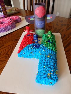 a cake shaped like the letter k on top of a white paper towel with blue and red frosting