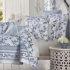 a bed with blue and white comforters on it