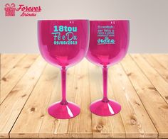 two pink wine glasses sitting on top of a wooden table with the words karla written in black