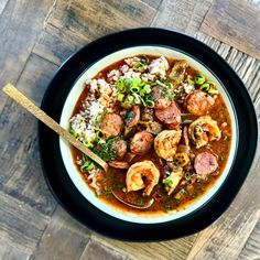 a bowl filled with shrimp and rice on top of a wooden table