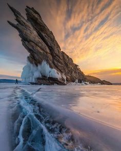 an ice covered beach with large rocks and water