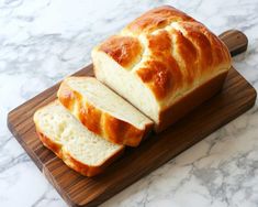 a loaf of bread sitting on top of a wooden cutting board