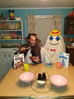 a man sitting at a table eating cereal with ghost in the back ground behind him