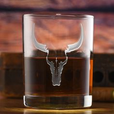 a shot glass with a bull's head etched on it