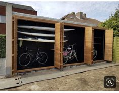 two bikes are parked in the back of a shed with surfboards attached to it