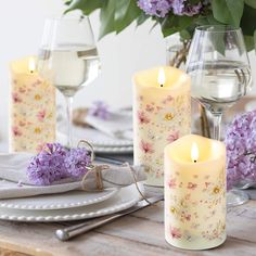 the table is set with purple flowers and candles