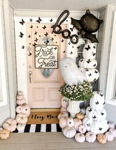 a front door decorated for halloween with pumpkins and other decorations