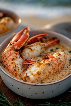 a bowl filled with shrimp and sauce on top of a wooden table