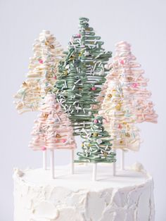 a cake with frosting and sprinkles on it is decorated like christmas trees