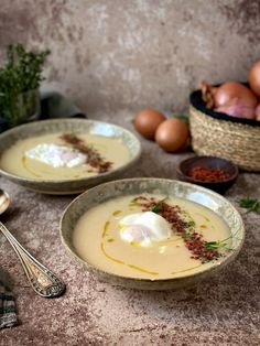 two bowls filled with soup next to some eggs