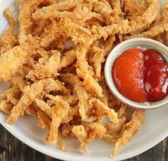 a white plate topped with fried food and ketchup