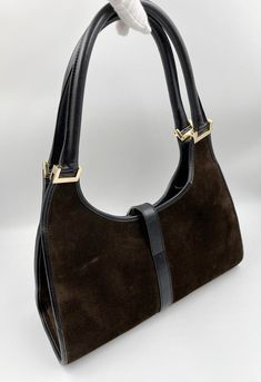 This bag is out of stock Please visit Gucci Collection A stunning vintage Gucci Jackie bag made from brown suede, black leather with gold hardware. Inside the bag is lined with a very special gold nylon lining and there is a zipped pocket for valuables. This bag is in very good vintage condition. There are some slight marks to the suede and minor wear to be seen on the gold hardware. A true collectors item, increasingly hard to find the vintage Jackie bag's with gold hardware. This bag also come Vintage Gucci Jackie, Timeless Handbag, Vuitton Bag, Luxe Fashion, Bags Designer Fashion, Exclusive Bag, Baby Bag, Kids Bags, Handbag Backpack