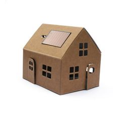 a small cardboard house with a solar panel on the roof and windows is shown in front of a white background