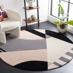 a living room with a white chair and black and pink rugs on the floor