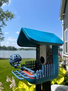 a blue bird house sitting on top of a metal pole