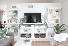 a living room filled with furniture and a flat screen tv on top of a white wall