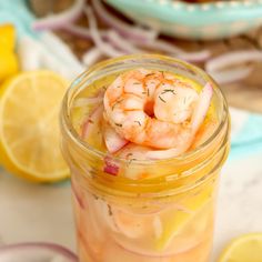 a jar filled with food sitting on top of a table next to sliced lemons