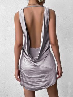 the back of a woman wearing a silver dress with an asymmetrical neckline