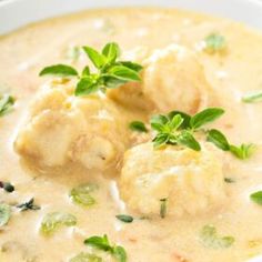 a close up of a bowl of food with broccoli and dumplings in it