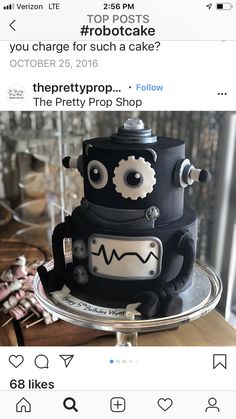 a black and white robot cake on top of a metal platter with the words robotcake below it