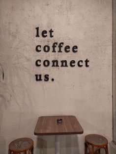 two chairs and a table in front of a wall that says let coffee connect us