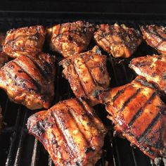 several pieces of meat cooking on a grill