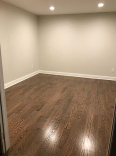 an empty room with hard wood flooring and white paint on the walls is seen in this image