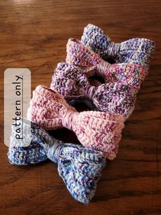 three crocheted bow ties sitting on top of a wooden table