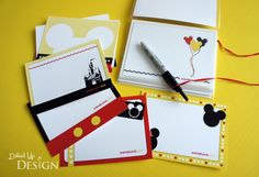 mickey mouse notepads and envelopes are on a yellow surface with red string