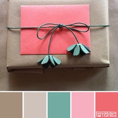 a present wrapped in brown paper with green leaves on top and pink, blue, and gray color palette