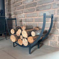 a stack of logs sitting in front of a brick wall next to a stove top oven