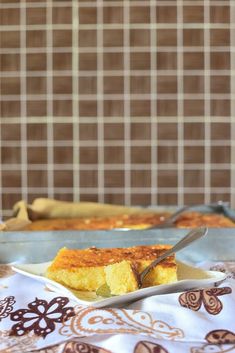 a piece of cornbread on a plate with a fork in front of the casserole