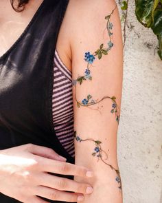 a woman's arm with blue flowers on it