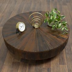 a wooden table with a clock and plant on it