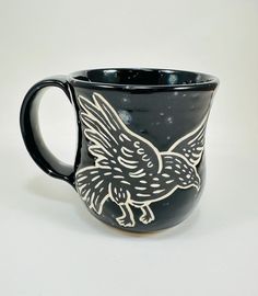 a black and white coffee mug with a bird on it