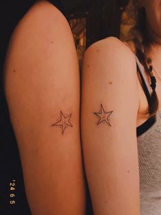 two women with matching tattoos on their legs, one has a star tattoo on the other