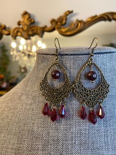 Elegant intriguing Statement earrings with Dark Garnet bead and Siam Red Swarovski crystals. Great for a holiday look or your next Steampunk get together! Talk about versatility! Ruby Chandelier Drop Earrings For Party, Red Crystal Metal Party Earrings, Red Crystal Metal Earrings For Parties, Elegant Red Metal Beaded Earrings, Elegant Red Beaded Metal Earrings, Red Metal Crystal Party Earrings, Red Nickel-free Drop Crystal Earrings, Handmade Burgundy Jewelry For Parties, Red Metal Dangle Beaded Earrings