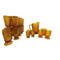 a group of yellow glass cups and saucers