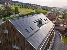 an aerial view of the roof of a building with many windows and shingled roofs