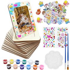 an assortment of crafting supplies including paints, stickers and paper with pictures on them